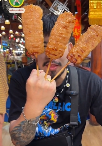 คนถือหมูปิ้งเสียบไม้
